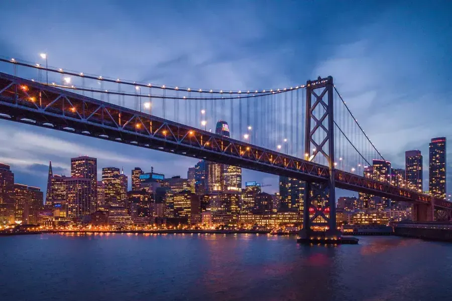 Il Bay Bridge e il lungomare dell'Embarcardero si illuminano di notte.